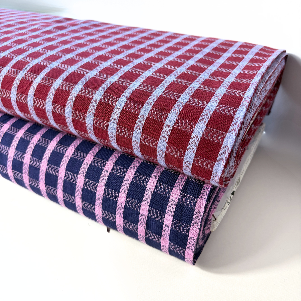 Navy pop pink dobby check woven cotton fabric folded to show raised 1.8cm grid texture and soft construction — 145cm wide lightweight dressmaking fabric for handmade blouses dresses and skirts
