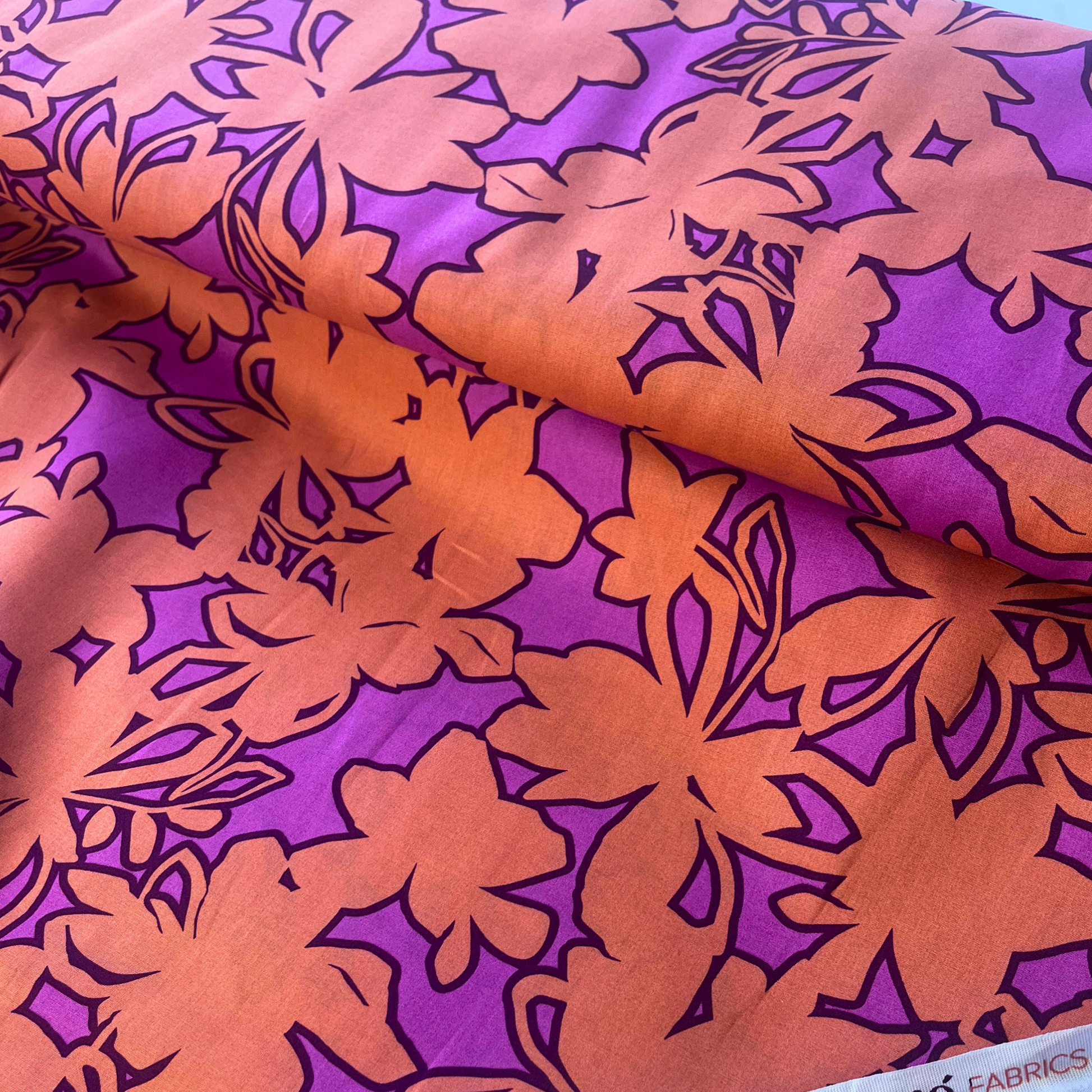 Close-up of orange and cerise pink stencil floral cotton poplin showing bold abstract floral print with tonal monochromatic quality — Oeko-Tex certified 110gsm 100% cotton woven ideal for slow fashion statement dressmaking