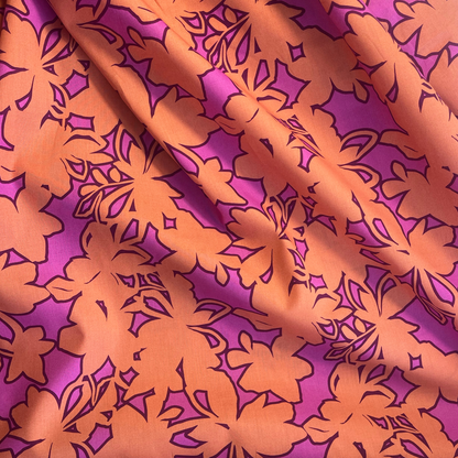 Bold stencil floral poplin fabric in orange and cerise pink tonal monochromatic print, 148cm wide — lightweight 110gsm 100% cotton woven, Oeko-Tex Standard 100 certified for handmade blouses, shirt dresses and wide-leg trousers