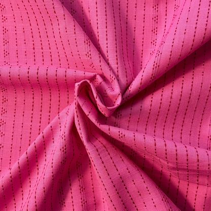 Pink and lilac dobby stripe yarn dyed woven cotton fabric folded to show raised vertical dot and dash texture — 145cm wide lightweight dressmaking fabric for handmade blouses shirts dresses and skirts