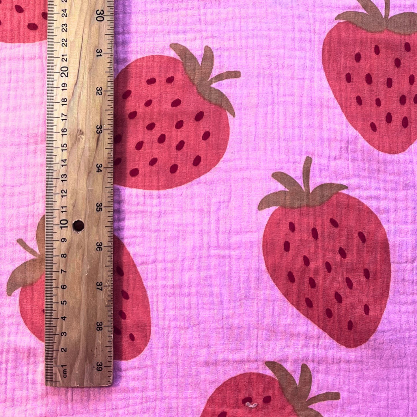 Washed pink double gauze fabric with large scale strawberry print in soft muted strawberry tones — Oeko-Tex Standard 100 certified 100% cotton two-layer woven for slow fashion dressmaking, children's clothing and handmade baby gifts