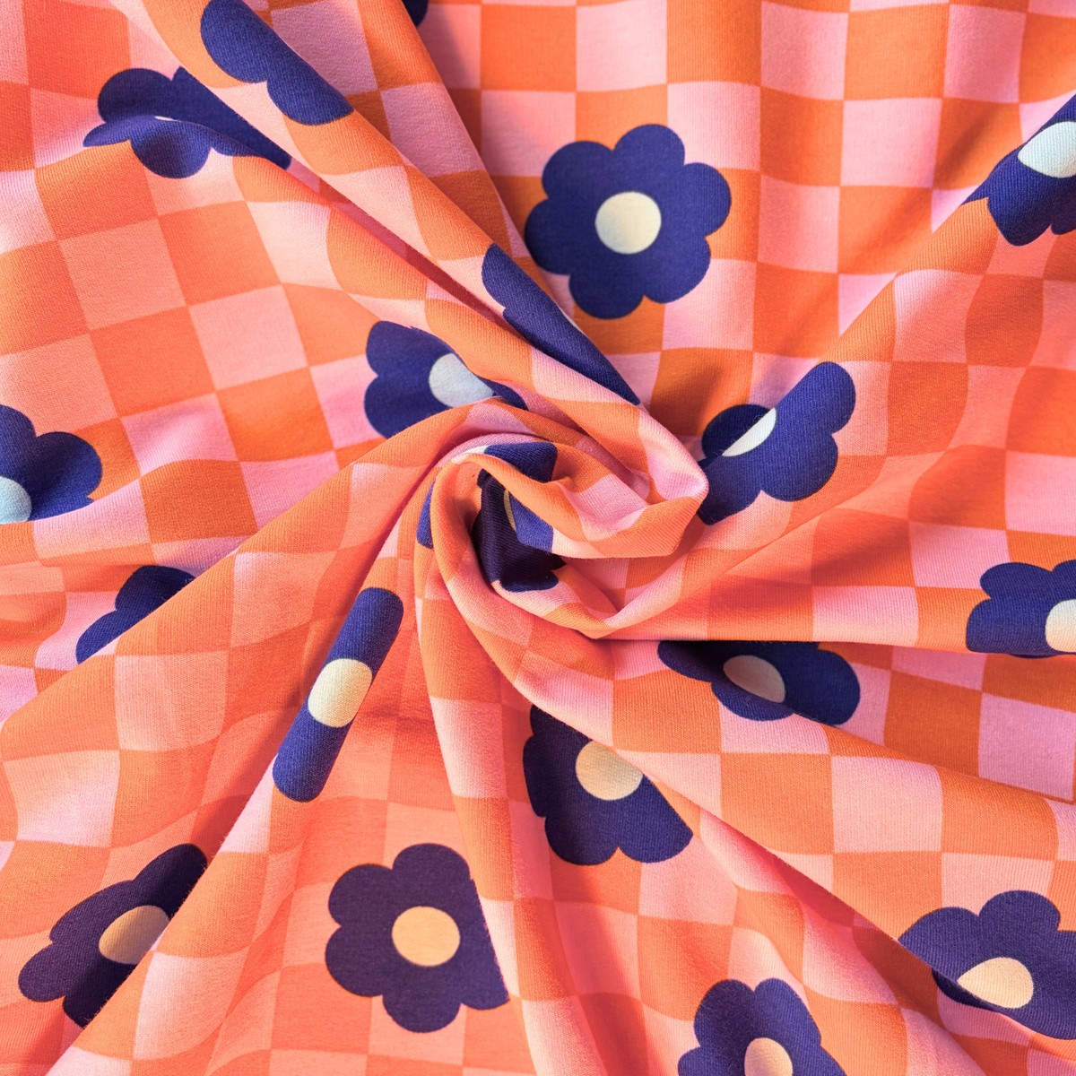 Orange and pink checkerboard sweatshirting with blue retro floral print — Oeko-Tex certified 95% cotton 5% elastane 225gsm brushed stretch knit for slow fashion sweatshirts joggers and co-ord sets