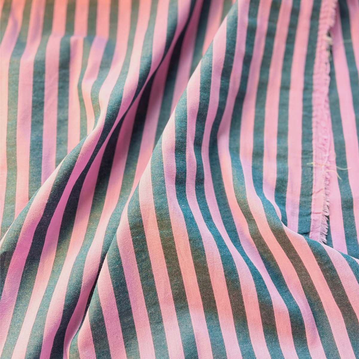 Washed pink petrol blue yarn dyed stripe cotton fabric flat lay showing 115gsm natural drape and 145cm width — romantic tonal stripe perfect for handmade blouses wide-leg trousers and relaxed dresses