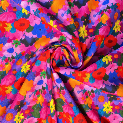 Wildflower Symphony needlecord fabric folded to show soft corduroy ridges and dense floral print, 112cm wide cotton corduroy for handmade skirts bags and soft furnishings