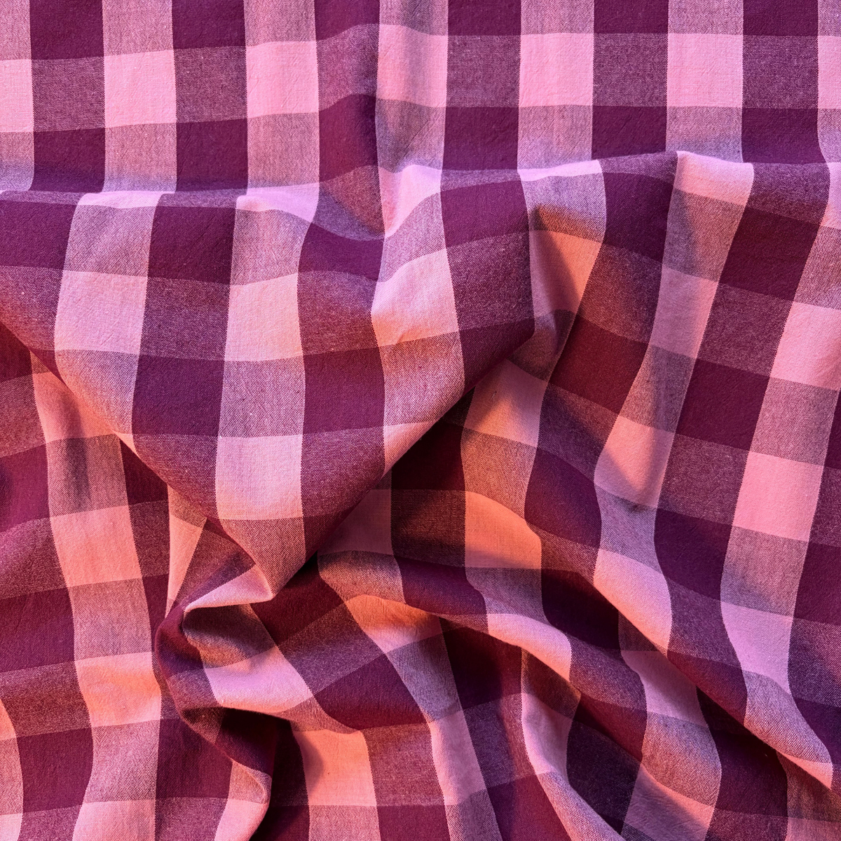Close-up of aubergine and pale pink yarn dyed gingham check woven cotton fabric showing rich 3cm check definition — 135gsm Oeko-Tex Standard 100 certified slow fashion dressmaking fabric UK