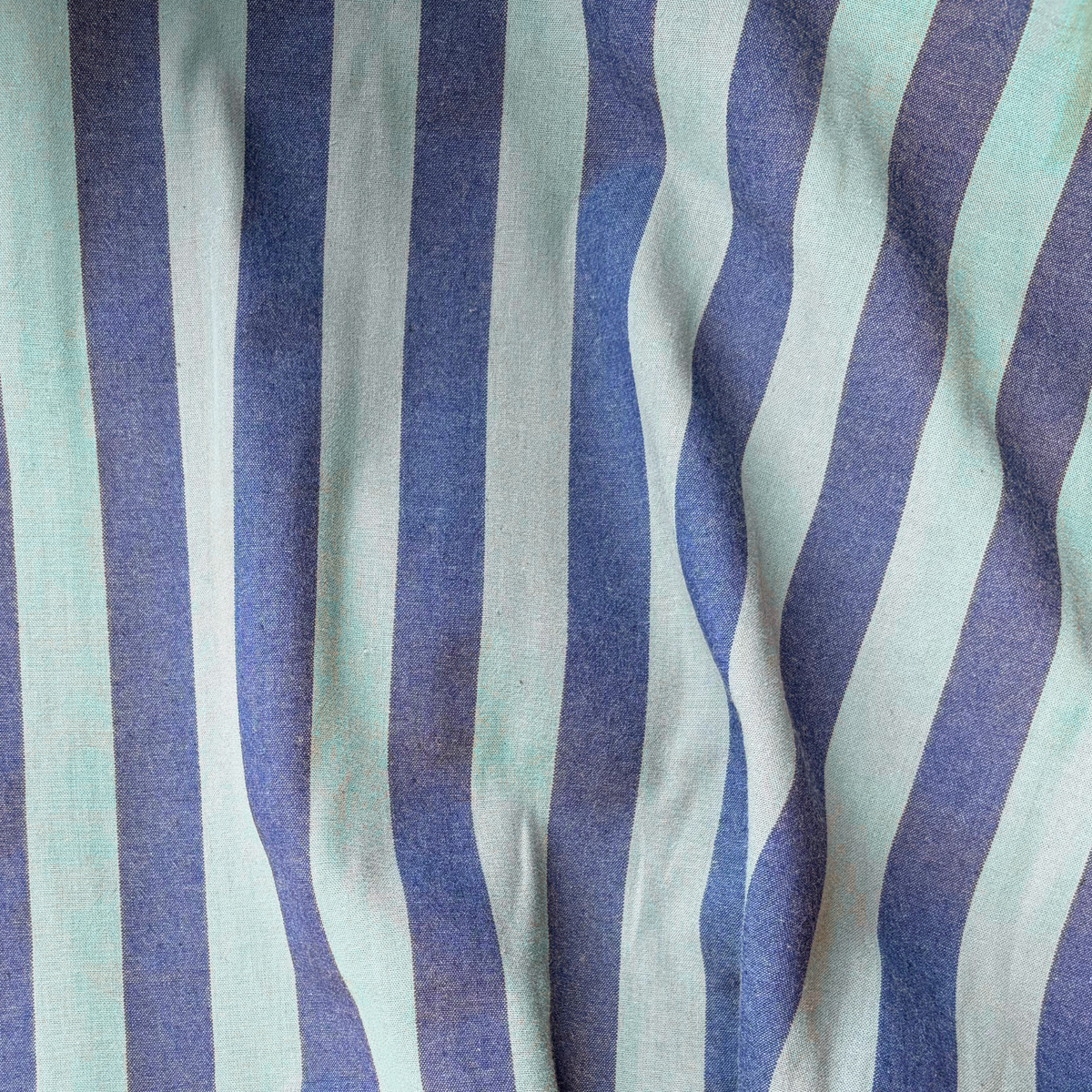 Close-up of blue and teal green yarn dyed vertical stripe cotton fabric — crisp 2.2cm stripe definition 135gsm woven Oeko-Tex Standard 100 certified slow fashion dressmaking fabric UK