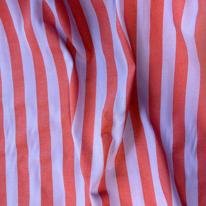 Close-up of burnt orange and lavender yarn dyed vertical stripe cotton fabric — crisp 2.2cm stripe definition 135gsm woven Oeko-Tex Standard 100 certified slow fashion dressmaking fabric UK