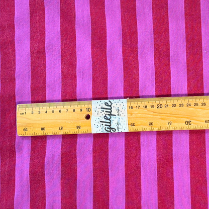 Close-up of red and cerise pink yarn dyed vertical stripe cotton fabric — crisp 2.2cm stripe definition 135gsm woven Oeko-Tex Standard 100 certified slow fashion dressmaking fabric UK