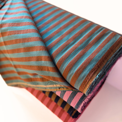 Close-up of washed brown and teal yarn dyed stripe woven cotton fabric showing soft 1.25cm stripe definition — 115gsm Oeko-Tex Standard 100 certified slow fashion dressmaking fabric UK