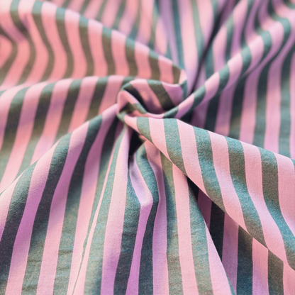 Close-up of washed pink and petrol blue yarn dyed stripe woven cotton fabric showing soft 1.25cm stripe definition — 115gsm Oeko-Tex Standard 100 certified slow fashion dressmaking fabric UK